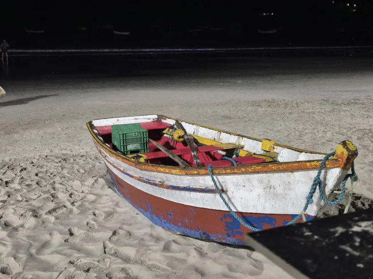 Pequeno barco de pesca colorido apoiado na areia da Praia de Garopaba