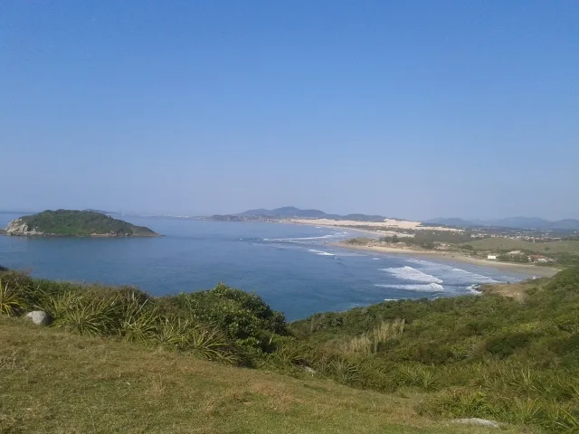 Vista do alto do morro da Praia do Rosa para a Praia do Luz e a Barra de Ibiraquera, com mar, areia e vegetação
